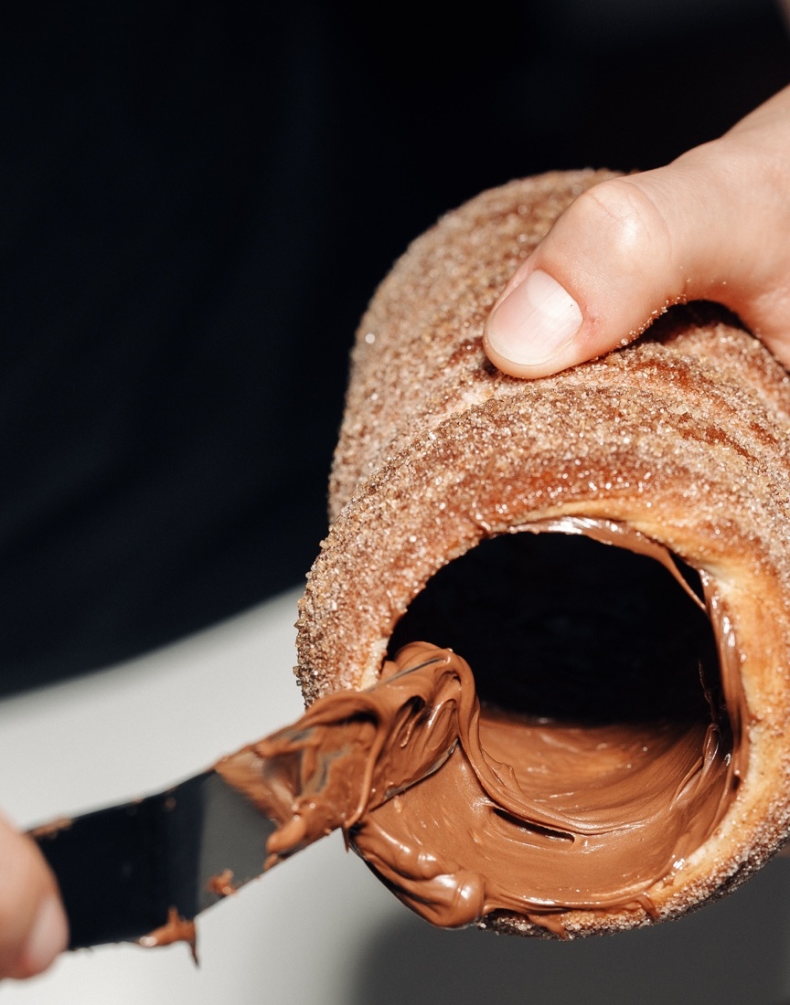 Fresh chimney cake being filled with chocolate